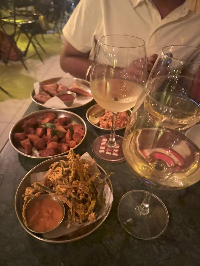 Wine and starters on a pub table at night
