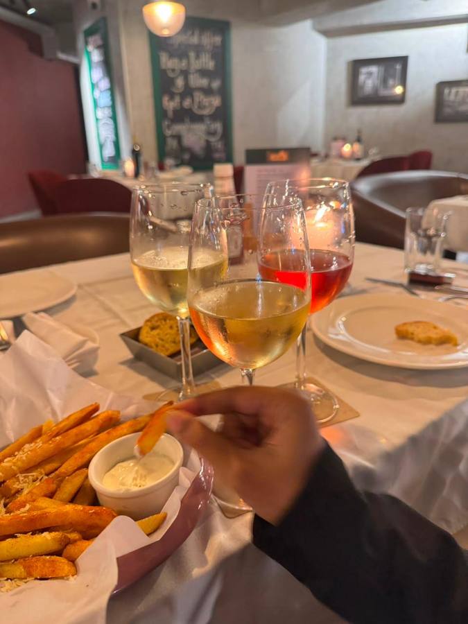 Three wine glasses and a basket of fries
