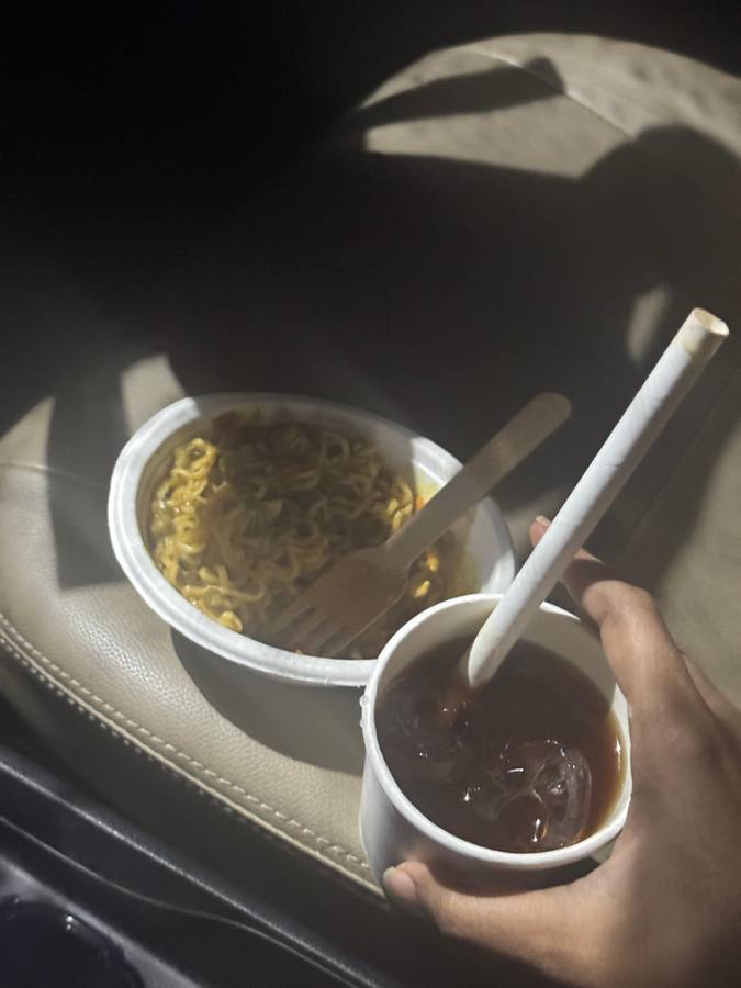 A cup of maggi and an iced coffee in the car