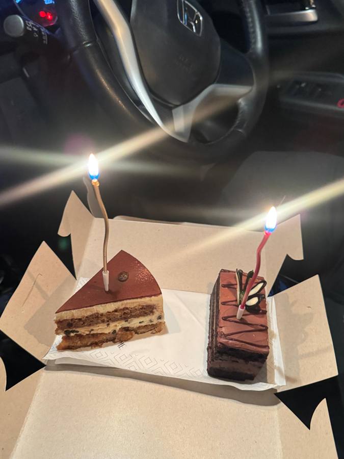 Two slices of cake with lit candles in the car