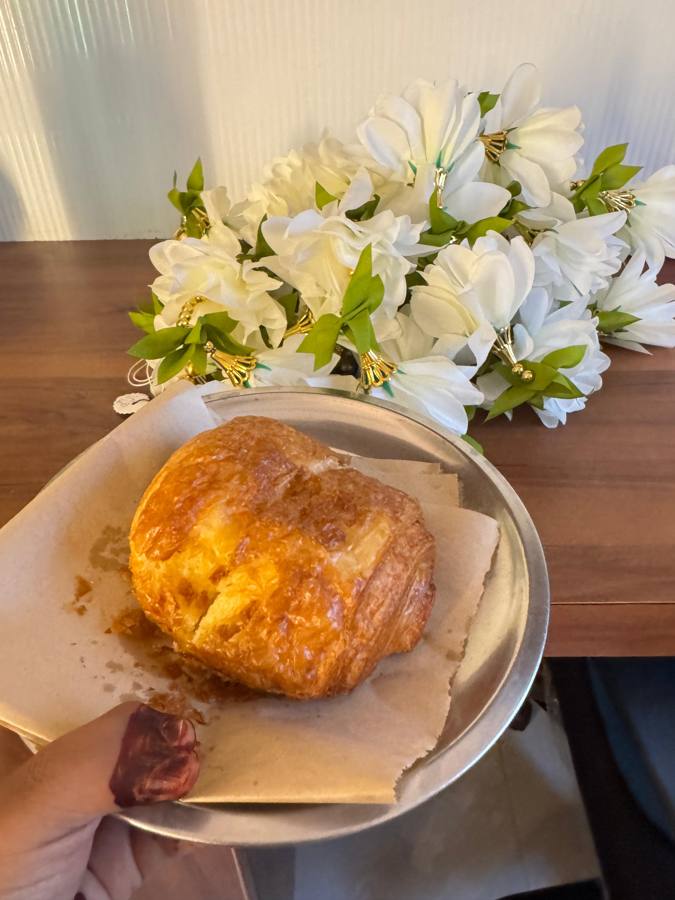 Pain au chocolat on a plate next to white flowers