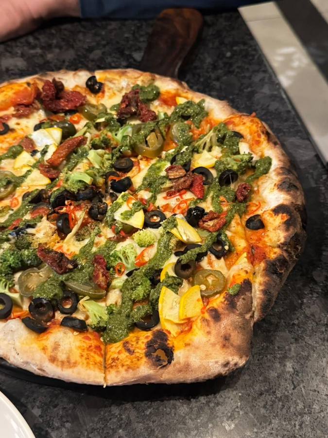 Pizza loaded with olives, chillies and pesto